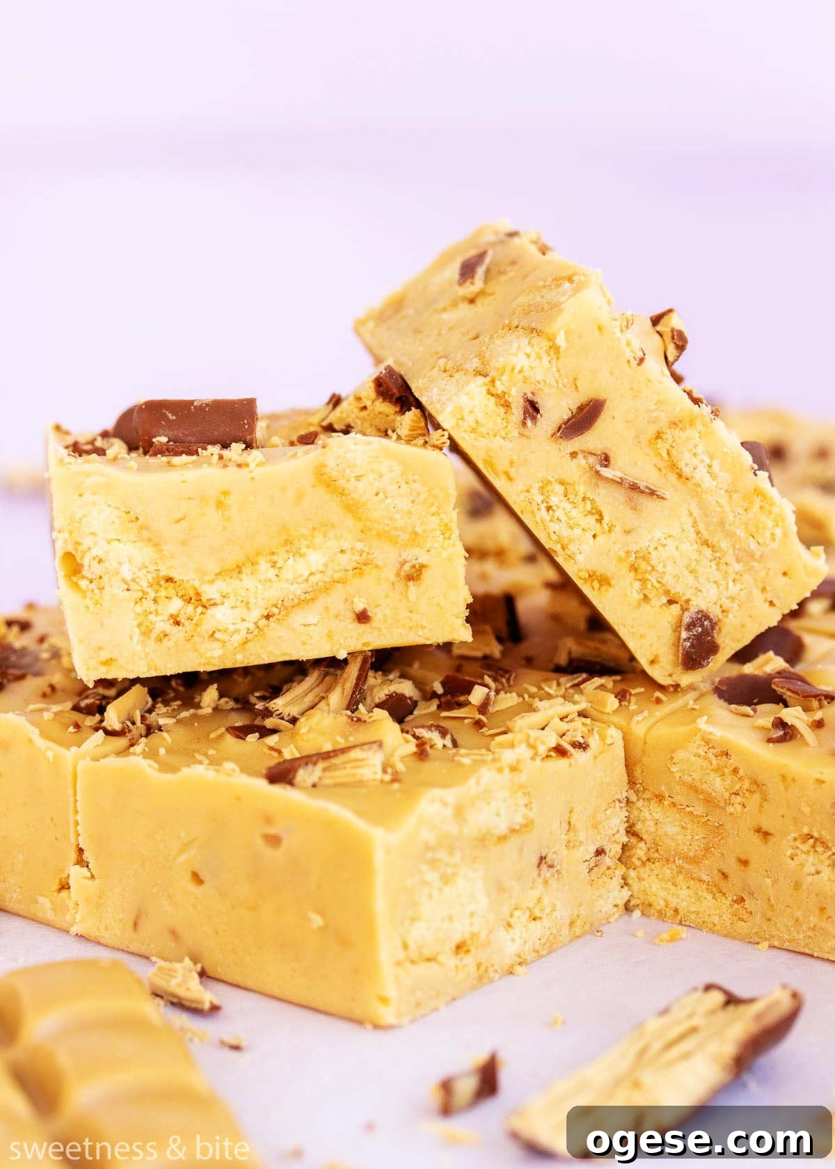 Two squares of slice showing the chunks of biscuit and chocolate inside.
