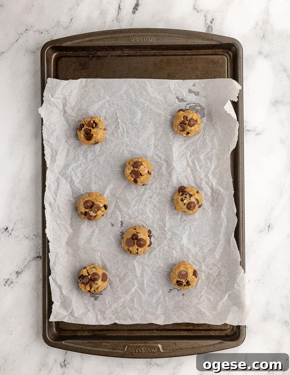 Gluten-Free Chocolate Chip Cookie Recipe You’ll Love 12 gluten free cookie dough balls on a sheet pan with parchment paper.