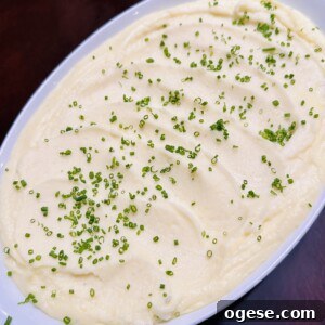 Ale’s Top Easter Recipes 2026: Festive Ideas for Your Holiday 11 A white oval dish filled with creamy mashed potatoes, topped with finely chopped chives and set on a dark wooden table.
