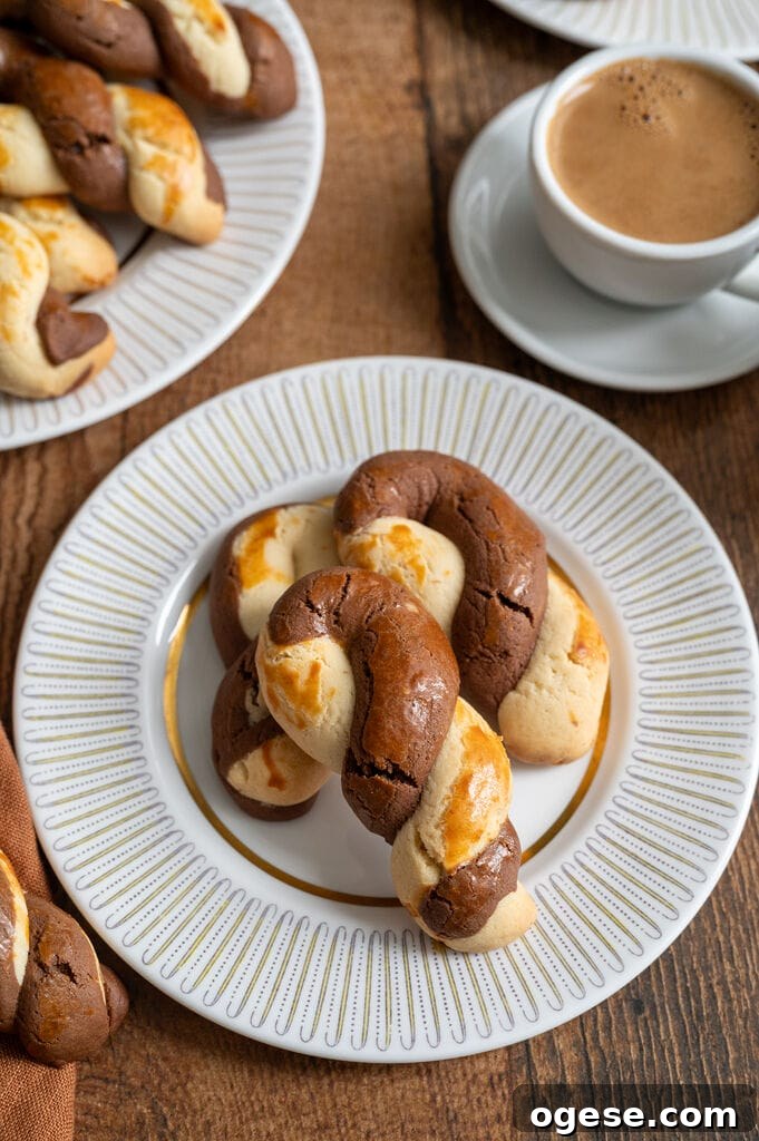 Greek Butter Koulourakia Cookies with Chocolate Swirl 23 Greek butter koulourakia with a chocolate twist on a white place with gold decor, and a cup of Greek coffee next to it.