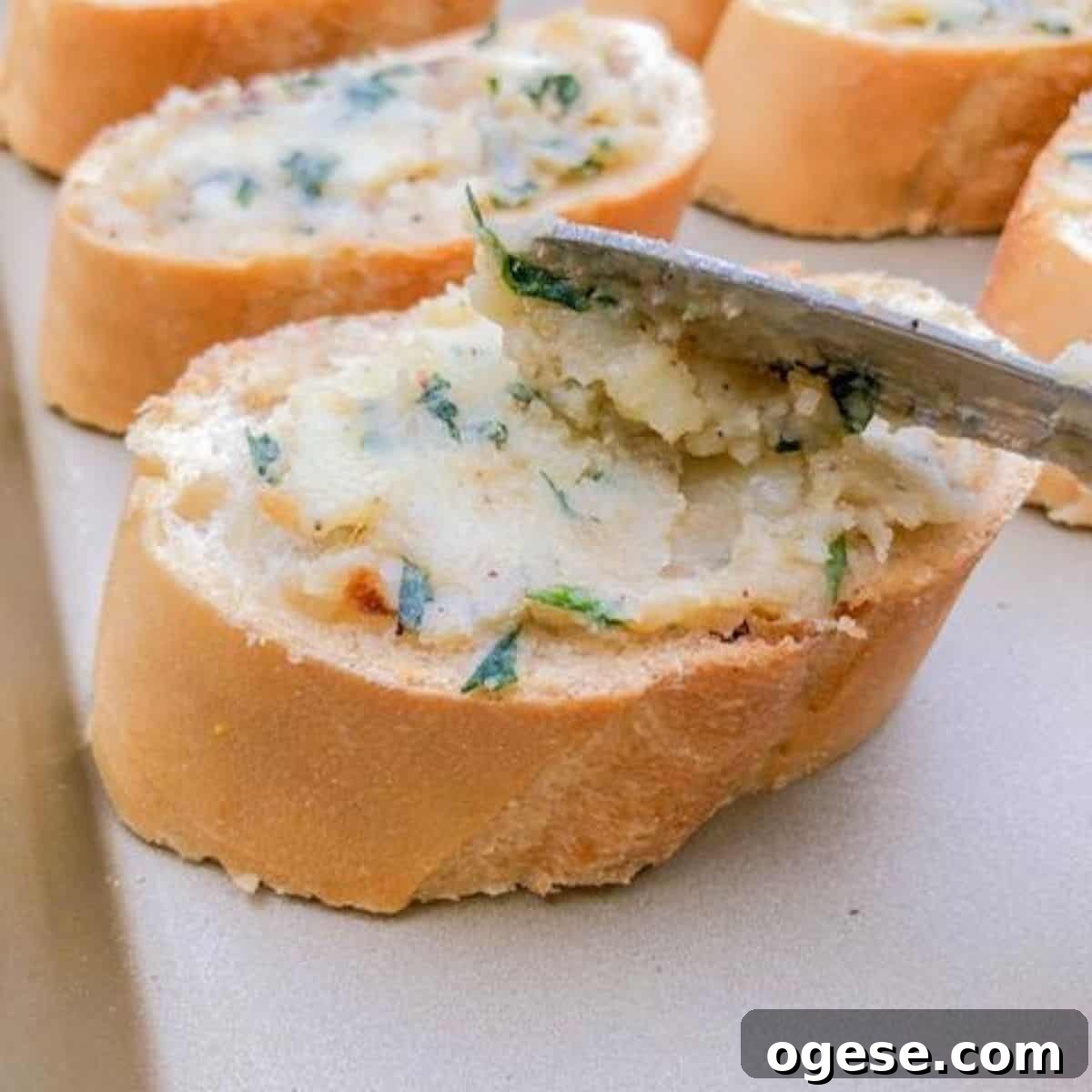 Spreading garlic butter onto bread.