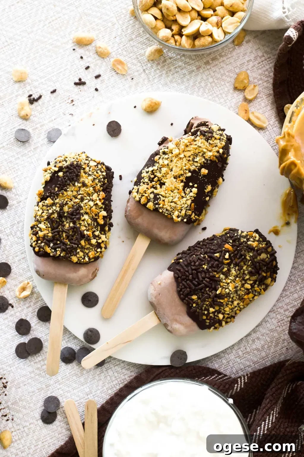 Chocolate Peanut Butter Cottage Cheese Ice Cream Bars — High-Protein Treat 15 Top view of three chocolate peanut butter cottage cheese ice cream bars with chocolate sprinkles and chopped peanuts on the outside.