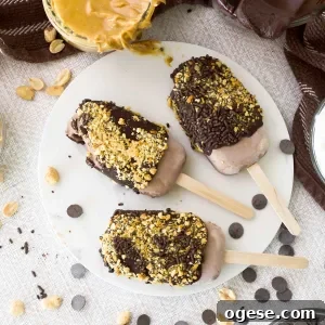 Chocolate Peanut Butter Cottage Cheese Ice Cream Bars — High-Protein Treat 16 Three chocolate peanut butter cottage cheese ice cream popsicles on a white marble trivet.