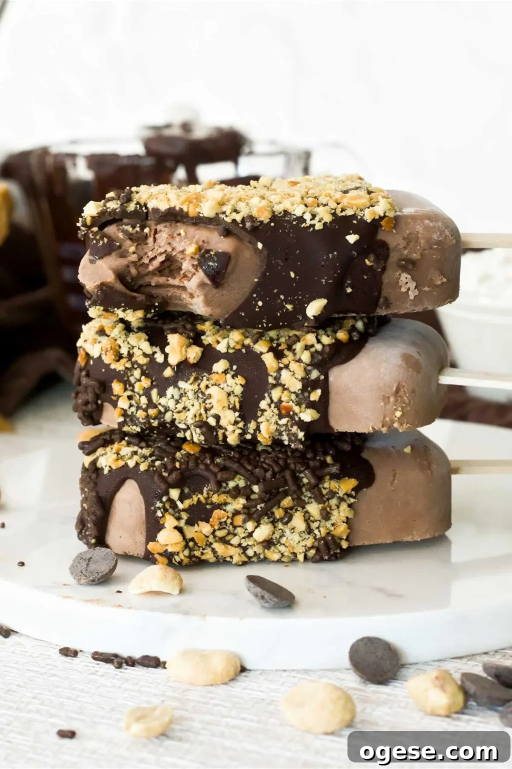 Chocolate Peanut Butter Cottage Cheese Ice Cream Bars — High-Protein Treat 3 A stack of three chocolate peanut butter cottage cheese ice cream bars with chopped peanuts and chocolate sprinkles on the outside.