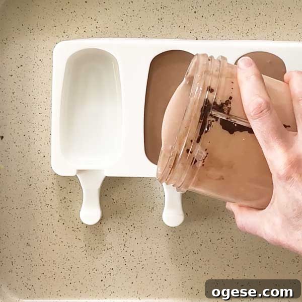 Chocolate Peanut Butter Cottage Cheese Ice Cream Bars — High-Protein Treat 7 Pouring the cottage cheese ice cream mixture into the popsicle mold.