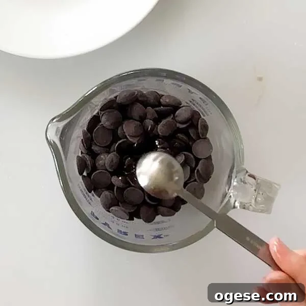 Chocolate Peanut Butter Cottage Cheese Ice Cream Bars — High-Protein Treat 10 Adding coconut oil to the chocolate chips in a microwave-safe measuring bowl.