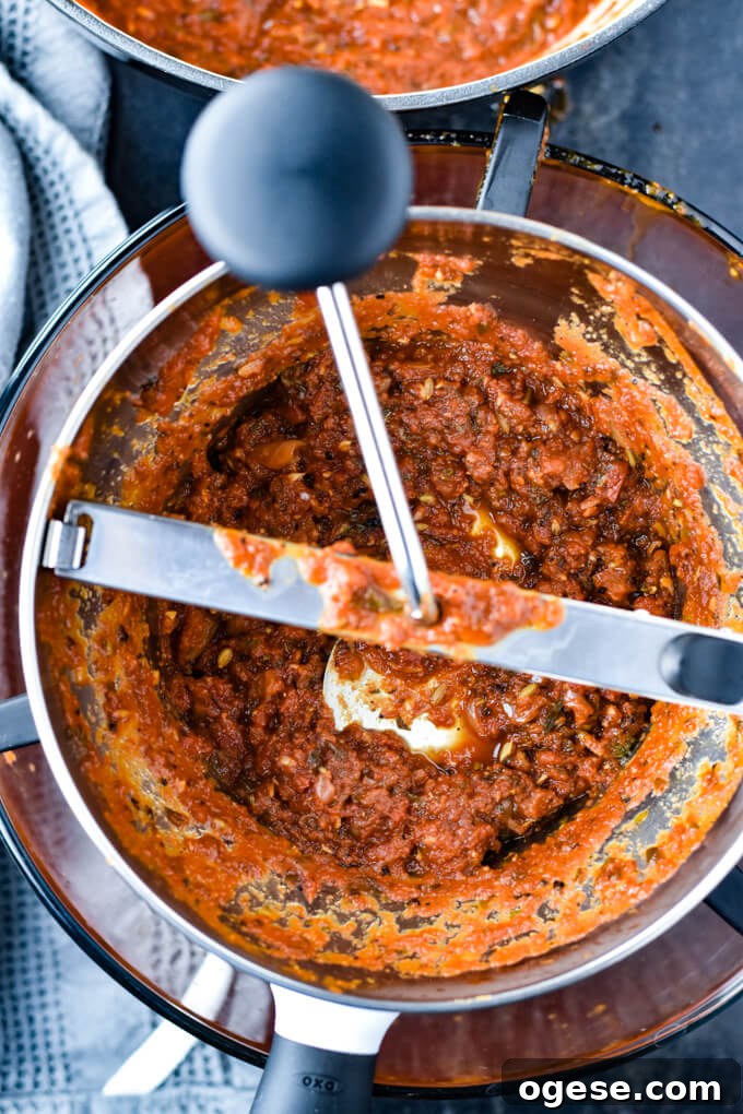 Authentic Homemade Pasta Sauce Recipe for Rich, Simple Flavor 6 A food mill grinding spaghetti sauce.
