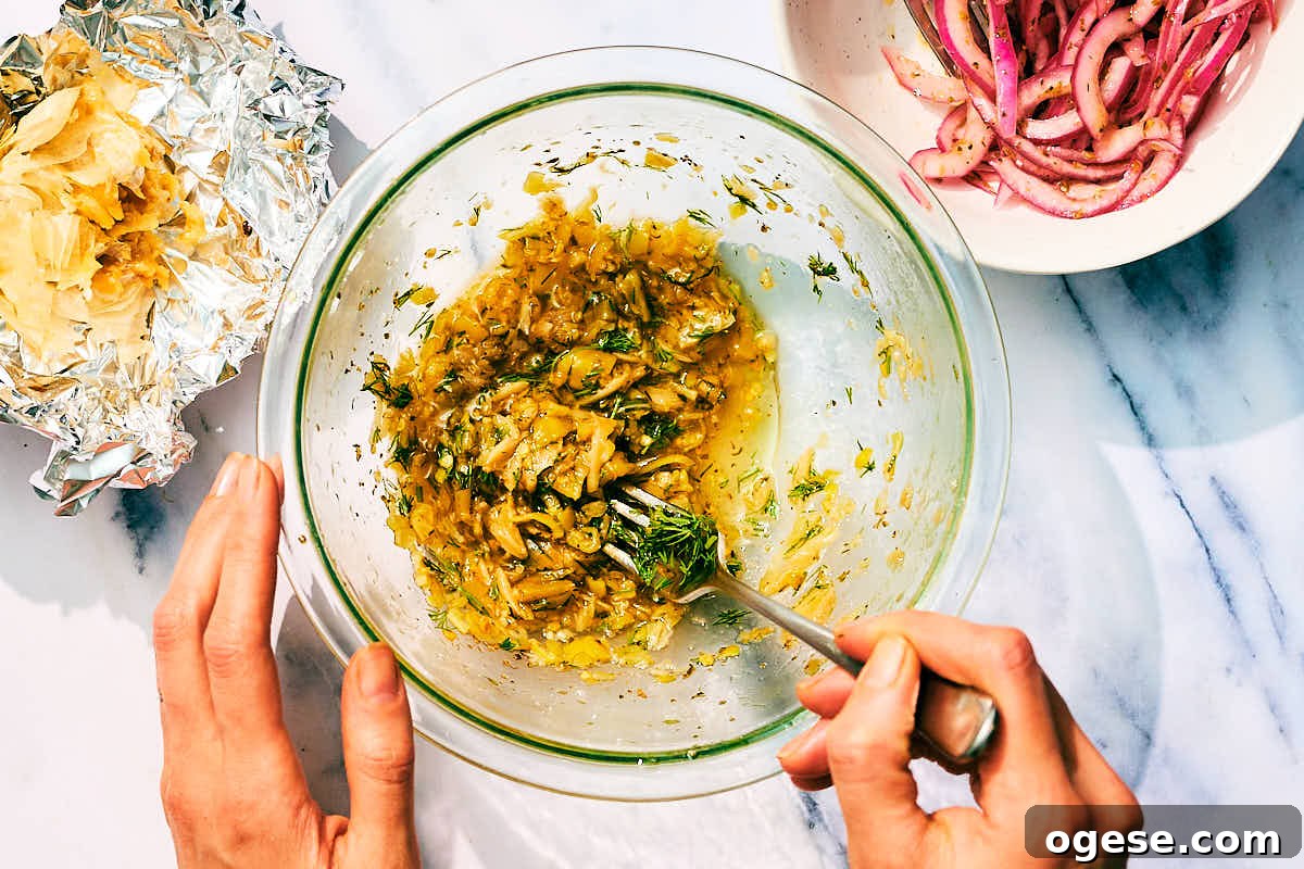 Pepperocini, roasted garlic, dill being whisked in a bowl for pepperocini dressing.