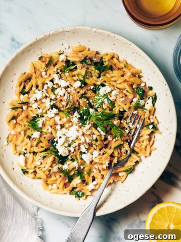 Lemon Spinach Orzo in a bowl topped with feta and dill.