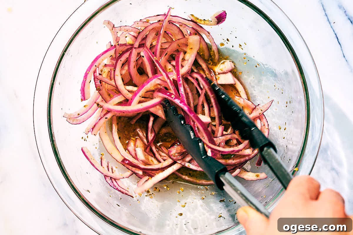 Marinated red onions being tossed in a bowl.
