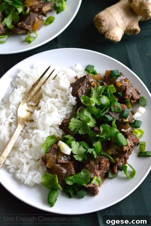 Slow Cooker Orange Ginger Beef Stew with Tender Chunks 4 overhead shot of a serving of slow cooker orange ginger beef with rice on the side and some fresh ginger in the background