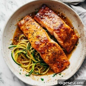 Maple glazed salmon in a pan with zucchini noodles.
