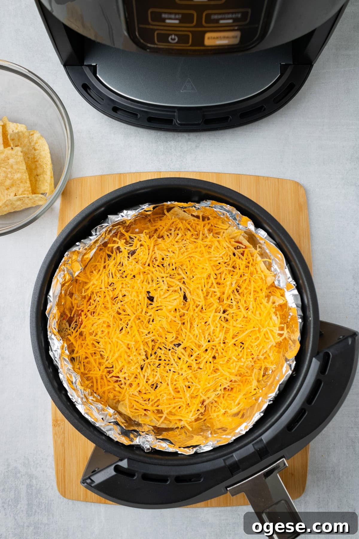 Crispy Air Fryer Nachos with Cheese & Quick Toppings 6 An overhead image of adding a layer of cheddar cheese.