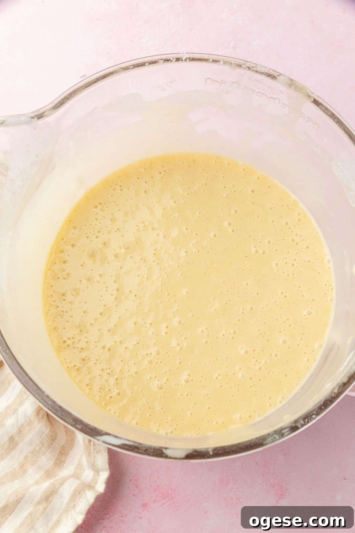 A glass mixing bowl with gluten free cake batter in it.