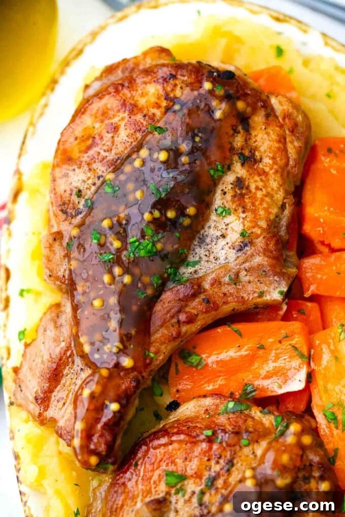 Sticky apple cider glaze on pork chop on top of mashed potatoes.