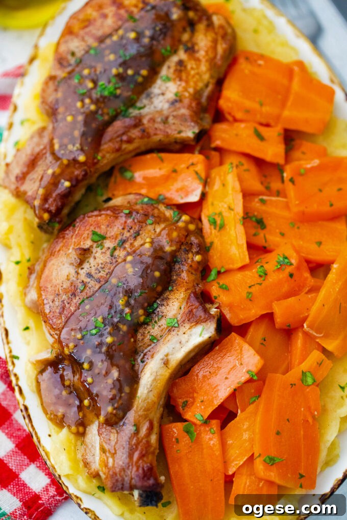 Homemade Instant Pot apple cider pork chops with carrot chunks and mashed potatoes.