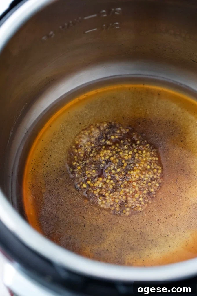 Making Instant Pot apple cider sauce with ground mustard and brown sugar.