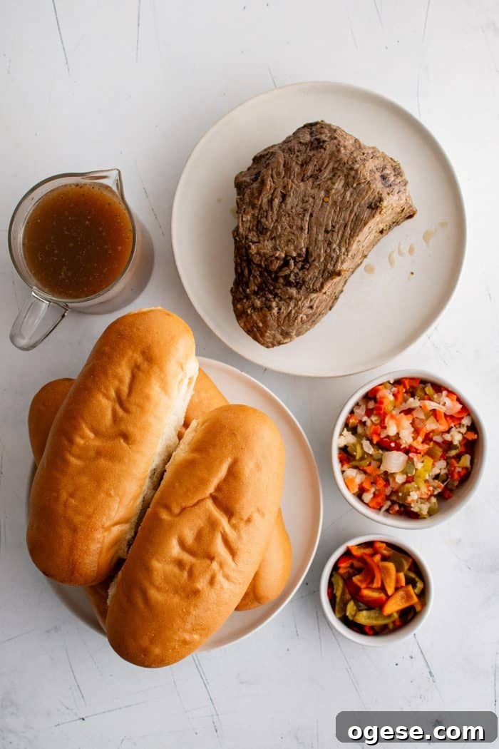 Classic Italian Beef Sandwich Recipe: Tender Slow-Cooked Roast Beef on Italian Bread 4 Ingredients needed to assemble Chicago-style Italian beef sandwiches including Italian rolls, cooked roast, au jus, hot cherry peppers, and Giardiniera.