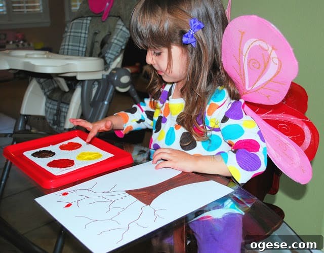 Fingerprint Fall Tree Crafts for Kids: Simple Autumn Art Project 7 child making fall craft