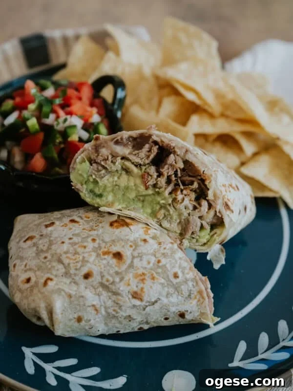 Carnitas burrito cut in half to reveal tender pulled pork