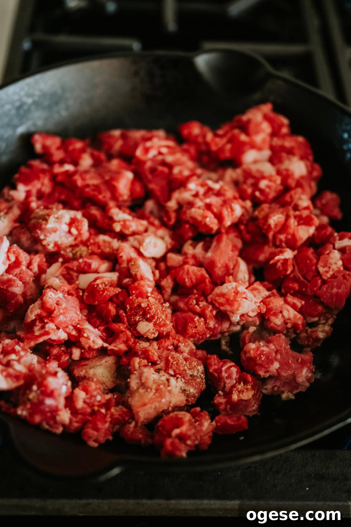 Seasoned beef taco meat cooking in a hot skillet.