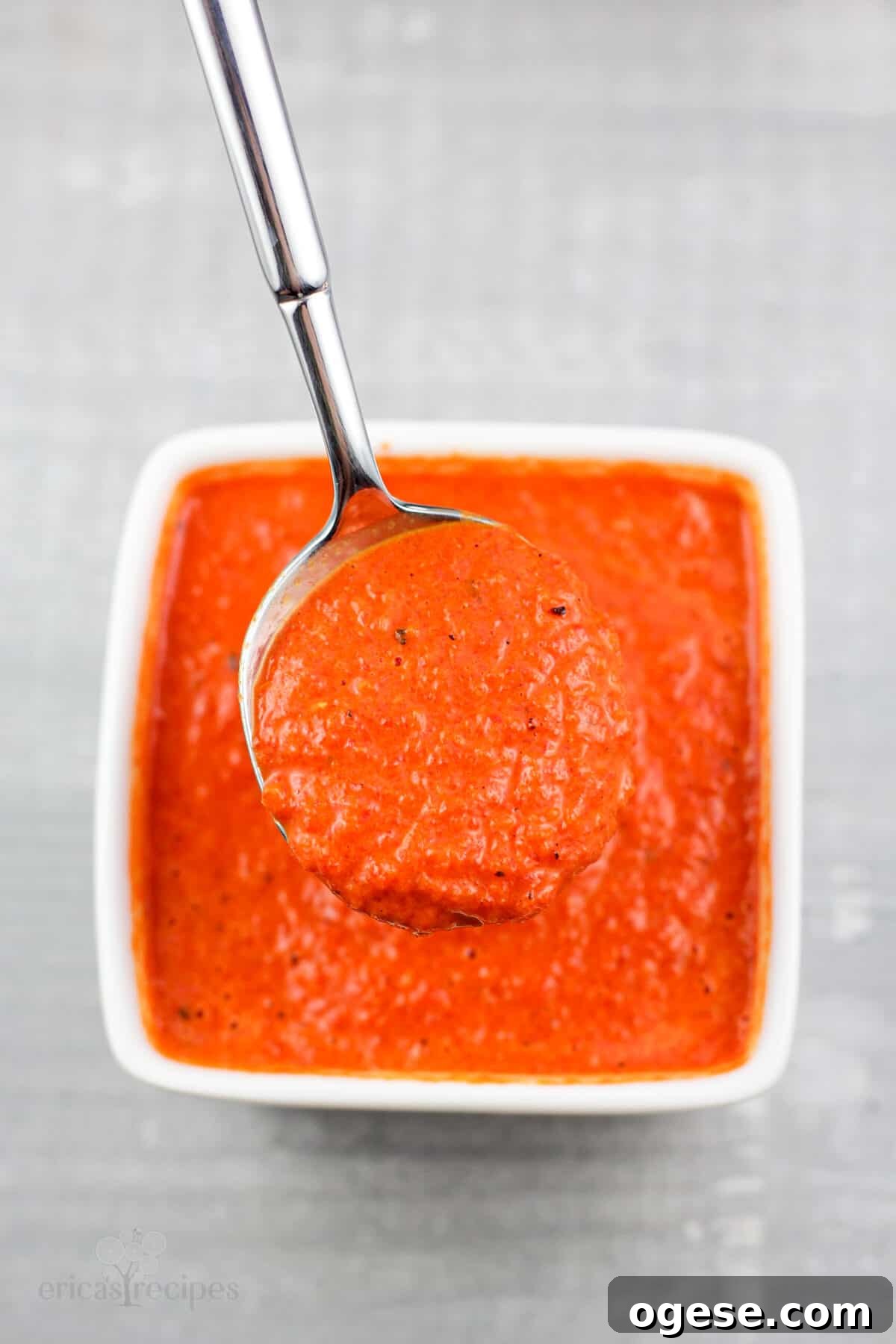 spoon holding coulis in small white bowl