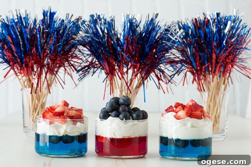 Patriotic 4th of July Fruit and Jello Cups Recipe 3 blue and red jello in glass cups topped with whipped cream and chopped strawberries and blueberries