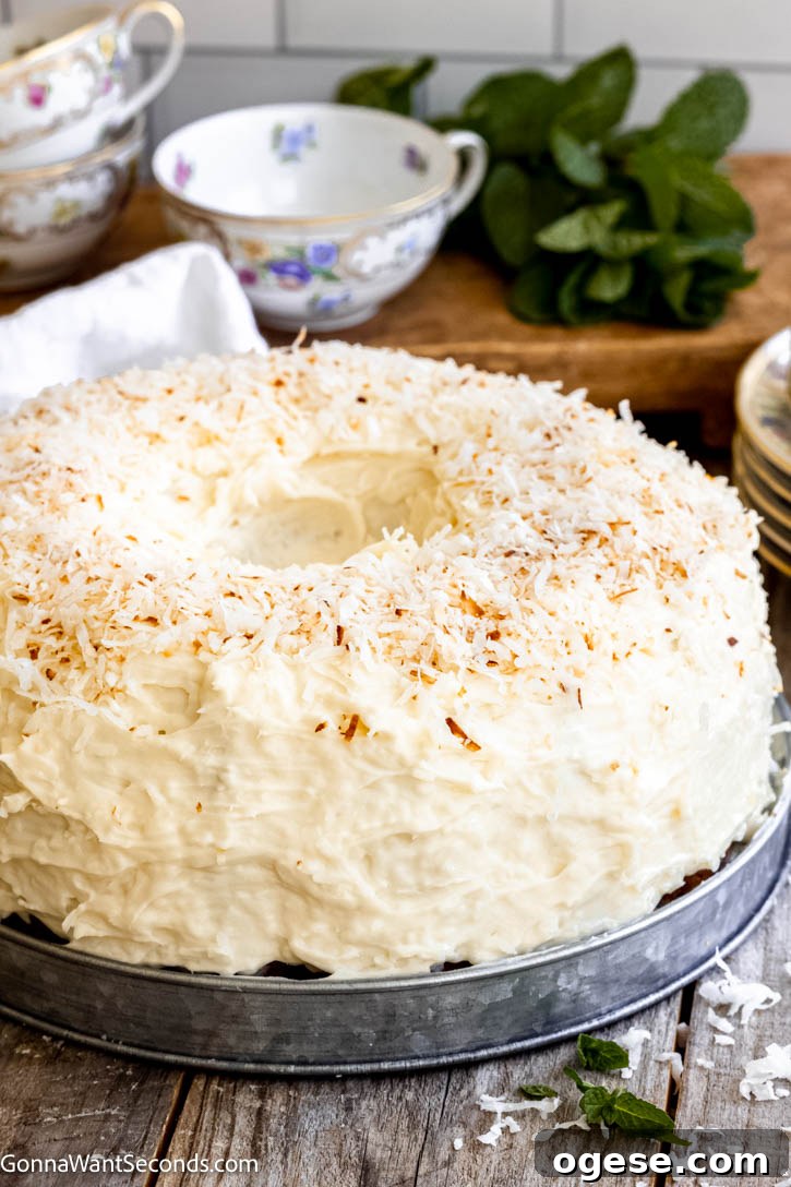 Our Tom Cruise cake features a rich coconut batter, a chewy coconut layer, and cream cheese frosting topped with coconut! Best cake EVER! #tomcruisecake #coconutcake Tom Cruise Cake with cream cheese frosting