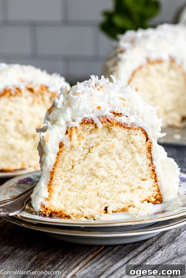 Our Tom Cruise cake features a rich coconut batter, a chewy coconut layer, and cream cheese frosting topped with coconut! Best cake EVER! #tomcruisecake #coconutcake a slice of Tom Cruise Cake