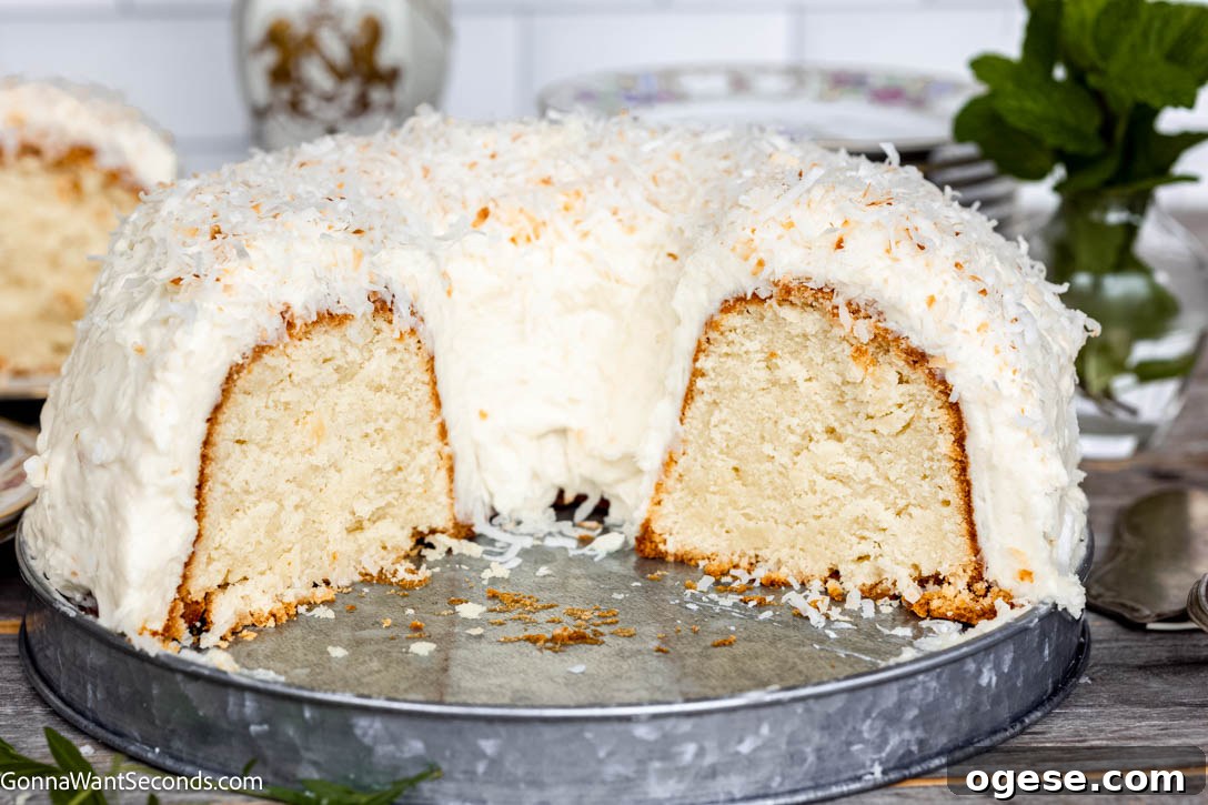 Our Tom Cruise cake features a rich coconut batter, a chewy coconut layer, and cream cheese frosting topped with coconut! Best cake EVER! #tomcruisecake #coconutcake Tom Cruise Cake sliced in half