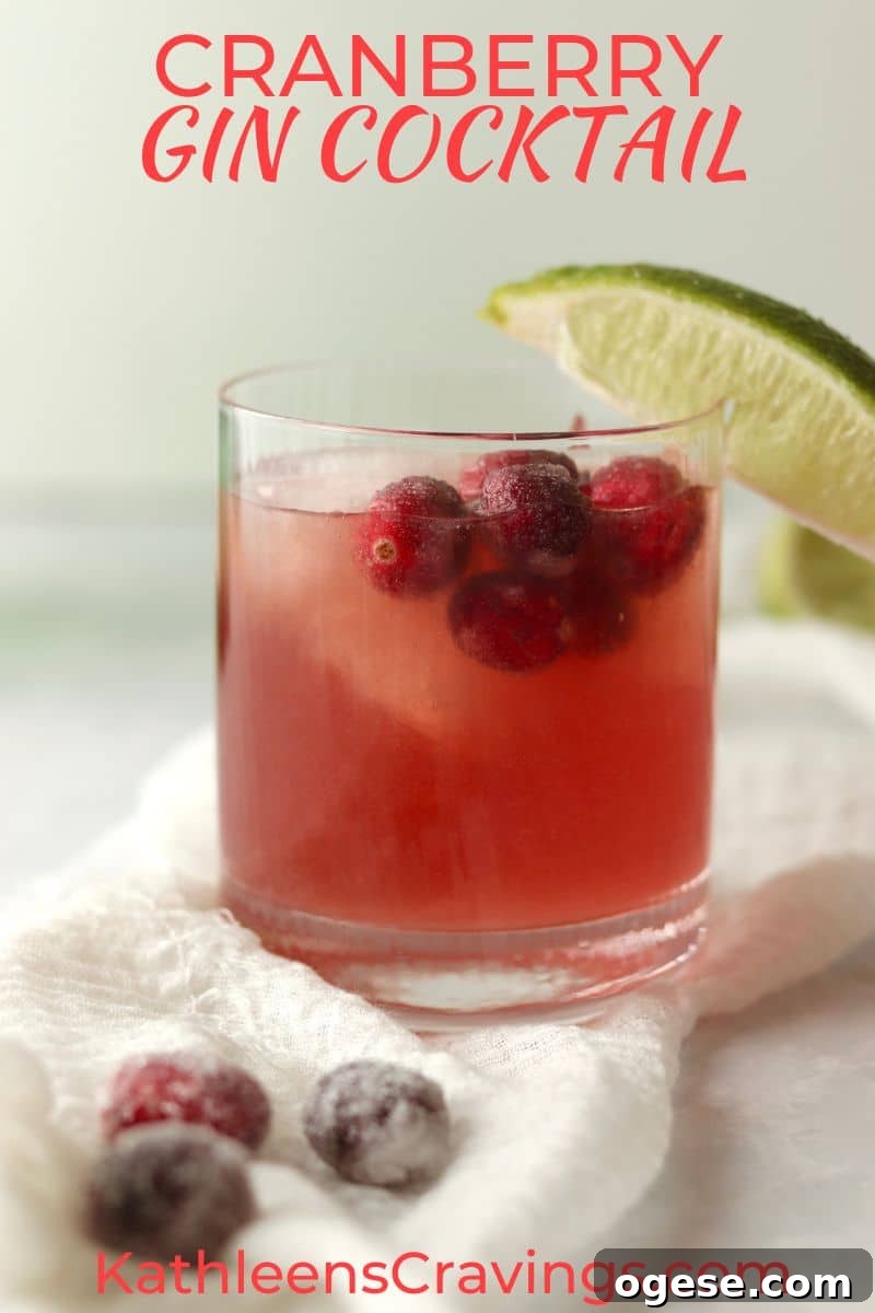 Cranberry Gin Cocktail with sugared cranberries and a lime wedge