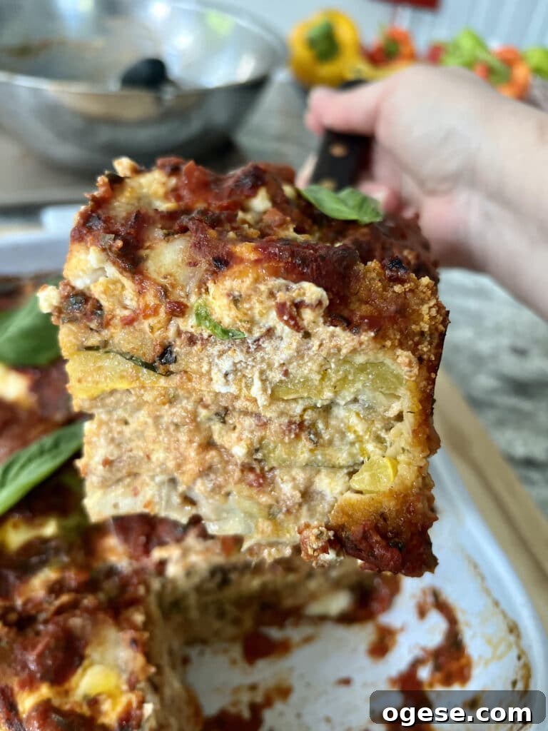Slice of parmigiana di zucchini held on spatula, showing the cut view.