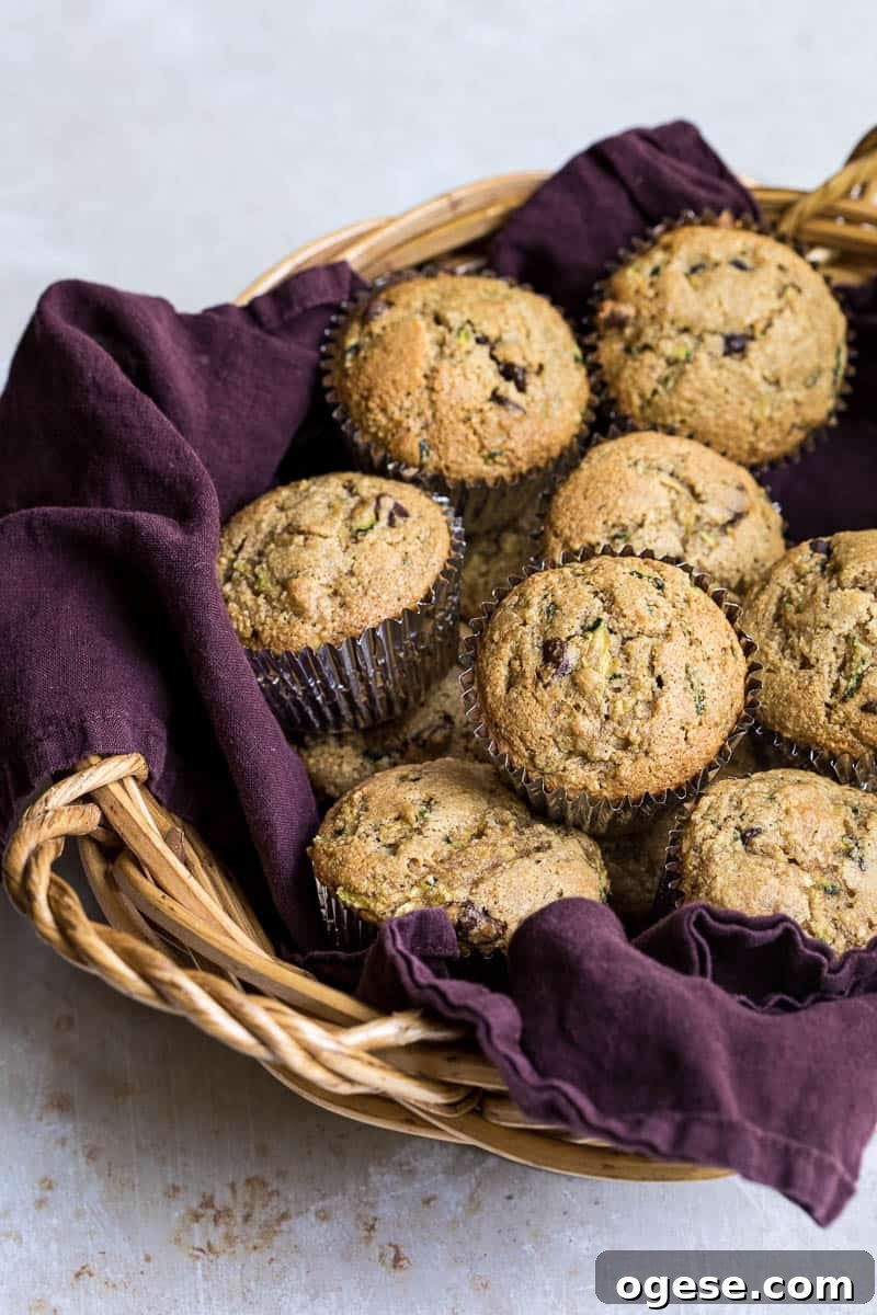 basket lined with purple napkin with stack of almond flour zucchini muffins.