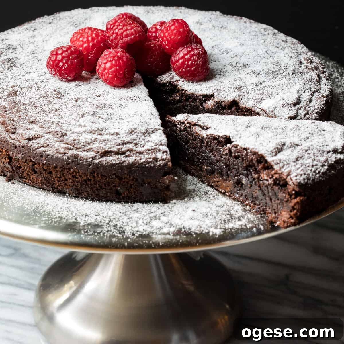 almond flour chocolate cake on cake stand with slice being removed