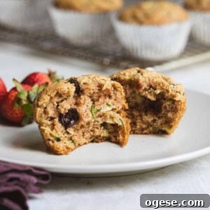 close-up of two halves of almond flour zucchini muffin on plate next to strawberries.
