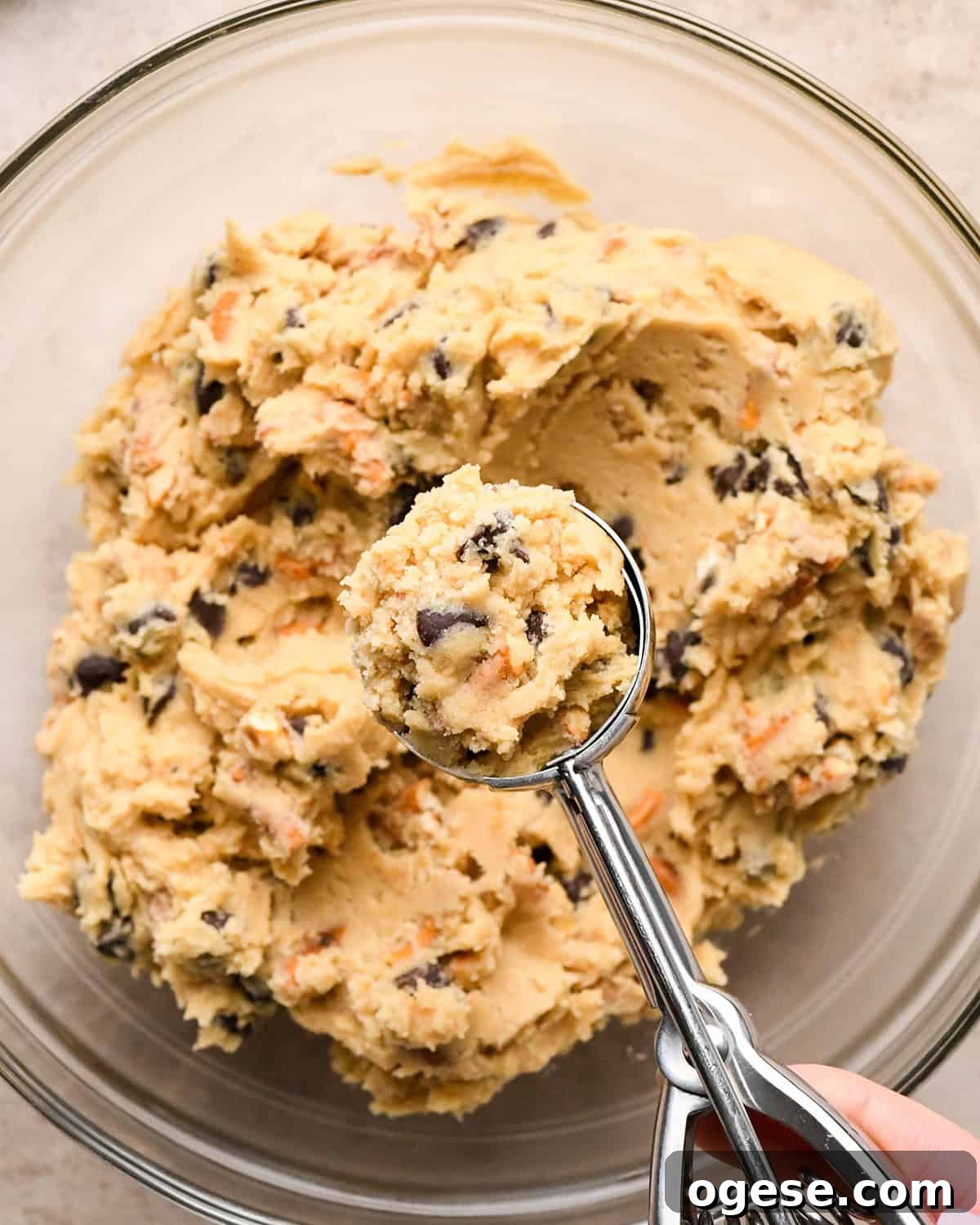 Salted Pretzel Chocolate Chip Cookies: Sweet Meets Crunch 16 a cookie scoop with a scoop of chocolate chip pretzel cookie dough in it