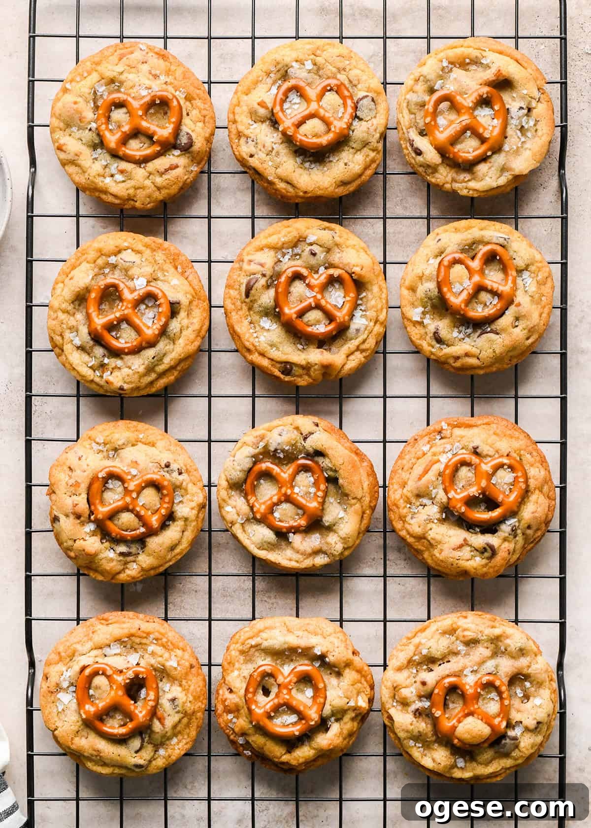 Salted Pretzel Chocolate Chip Cookies: Sweet Meets Crunch 23 12 Chocolate Chip Pretzel Cookies on a wire cooling rack each topped with a mini pretzel and flaky sea salt