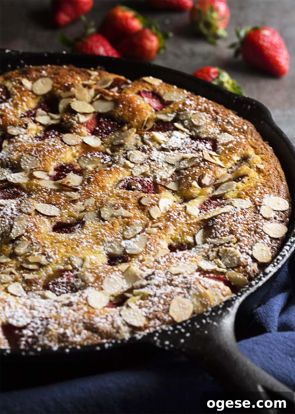 Strawberry yogurt skillet cake Strawberry yogurt skillet cake baked in a cast iron skillet topped with sliced almonds and powdered sugar.