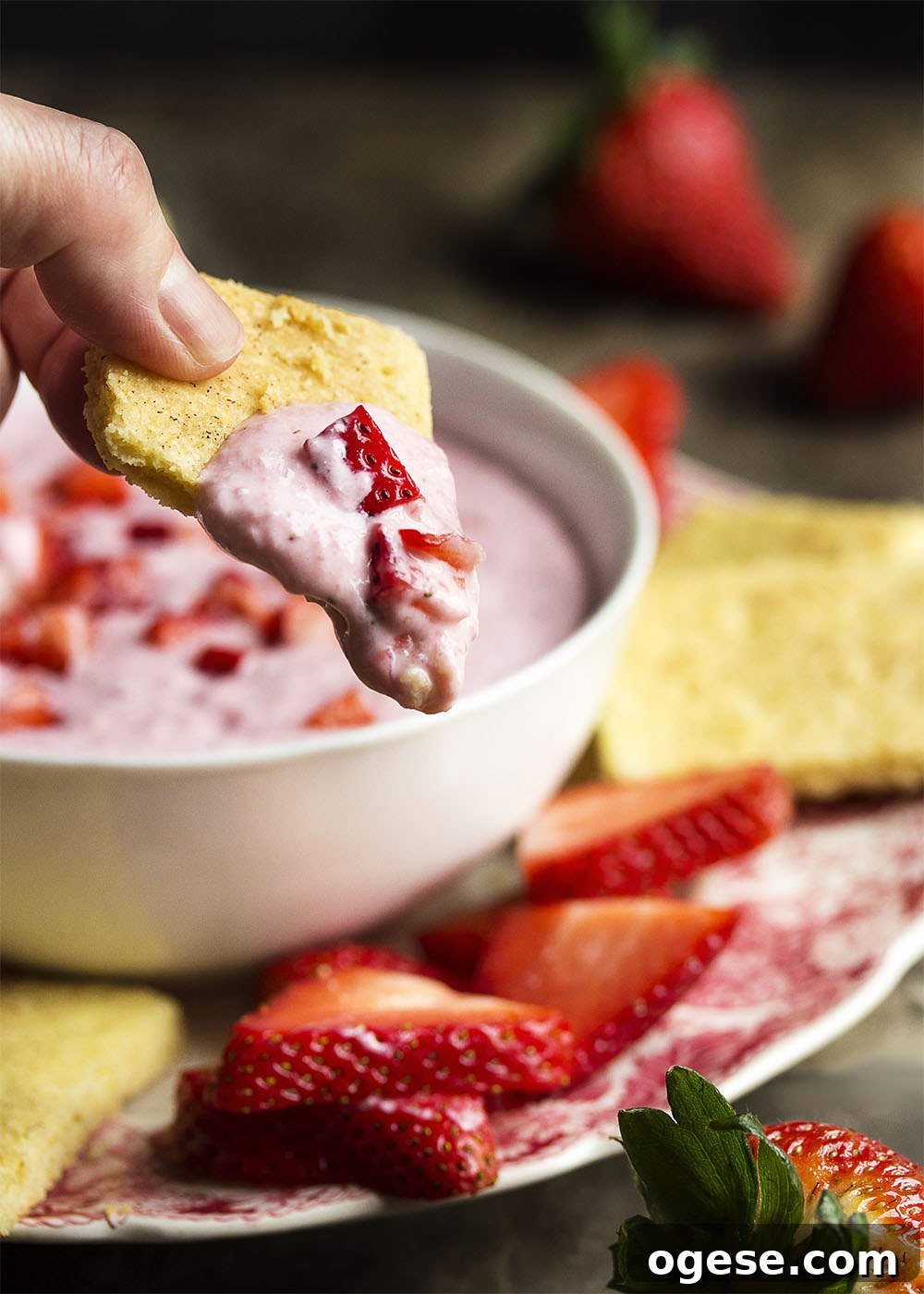 Strawberry shortcake dip A bowl of strawberry shortcake dip surrounded by sliced strawberries and lemon shortbread cookies.