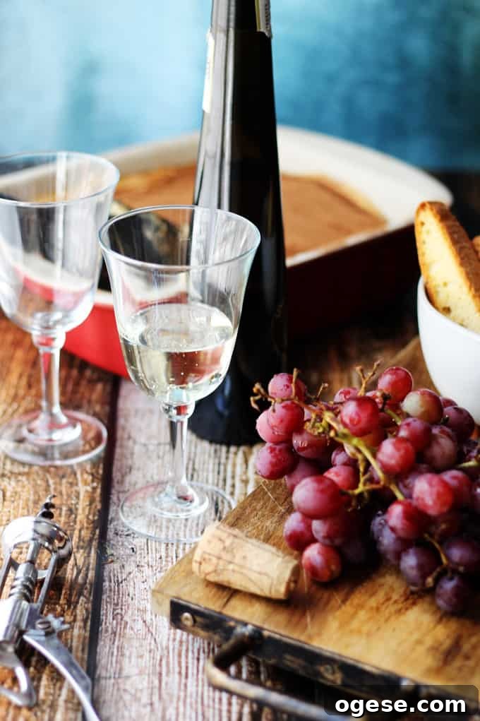 Italian Dessert Wine Moscato D'Asti in a glass with grapes and desserts on a side.