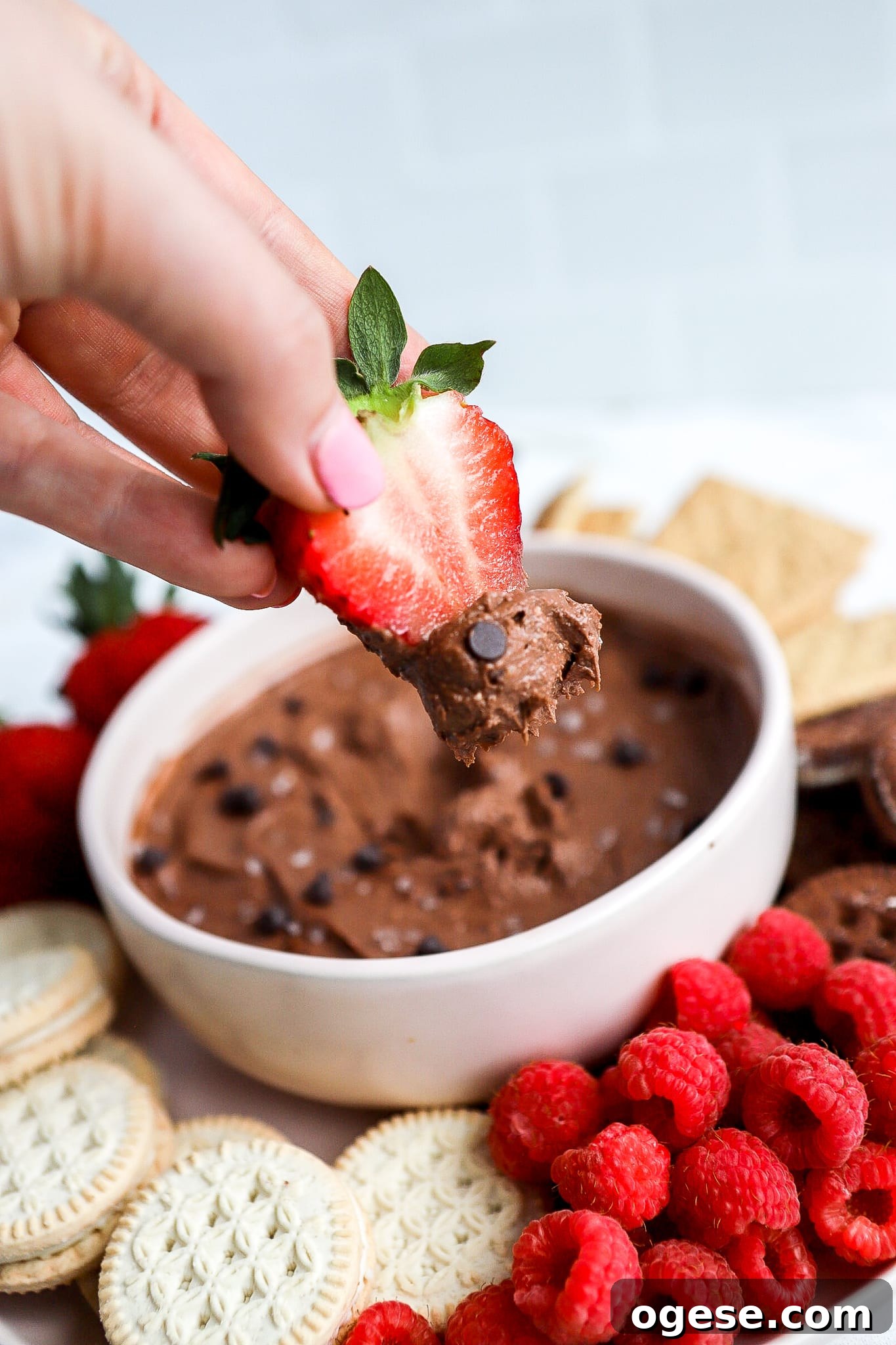Chocolate Cottage Cheese Fruit Dip: Creamy Chocolate Dessert Recipe 4 close up shot of strawberry dipped into cottage cheese fruit dip with dark chocolate chips
