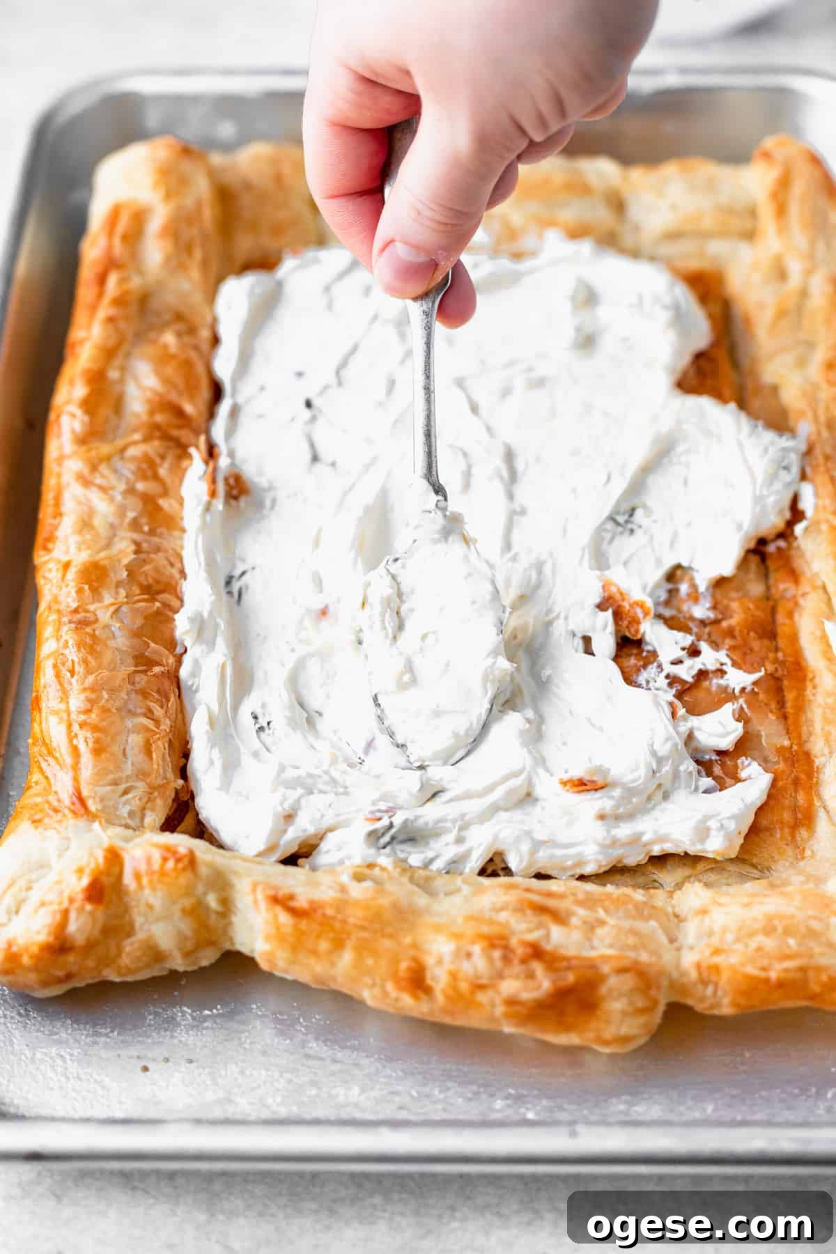 cream cheese mixture being spread on the puff pastry.