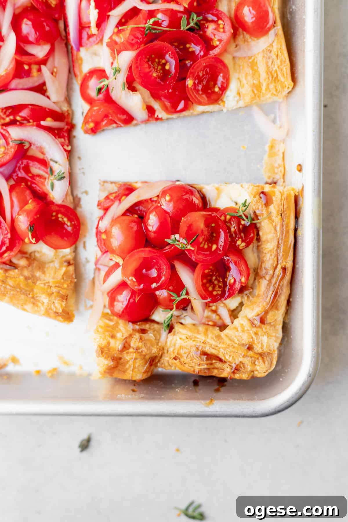 slice of tomato tart on a baking sheet ready to be enjoyed.