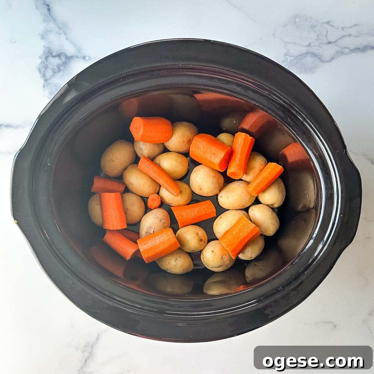 Slow Cooker Italian Pork Roast with Garlic and Herbs 11 A crock pot filled with carrots and potatoes.