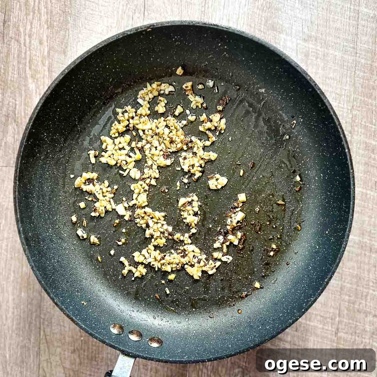 Slow Cooker Italian Pork Roast with Garlic and Herbs 13 Garlic cooking in oil in a frying pan.