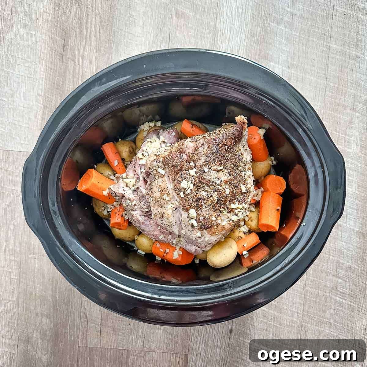 Slow Cooker Italian Pork Roast with Garlic and Herbs 15 A crock pot full of pork roast, potatoes, carrots, and cooking liquid.