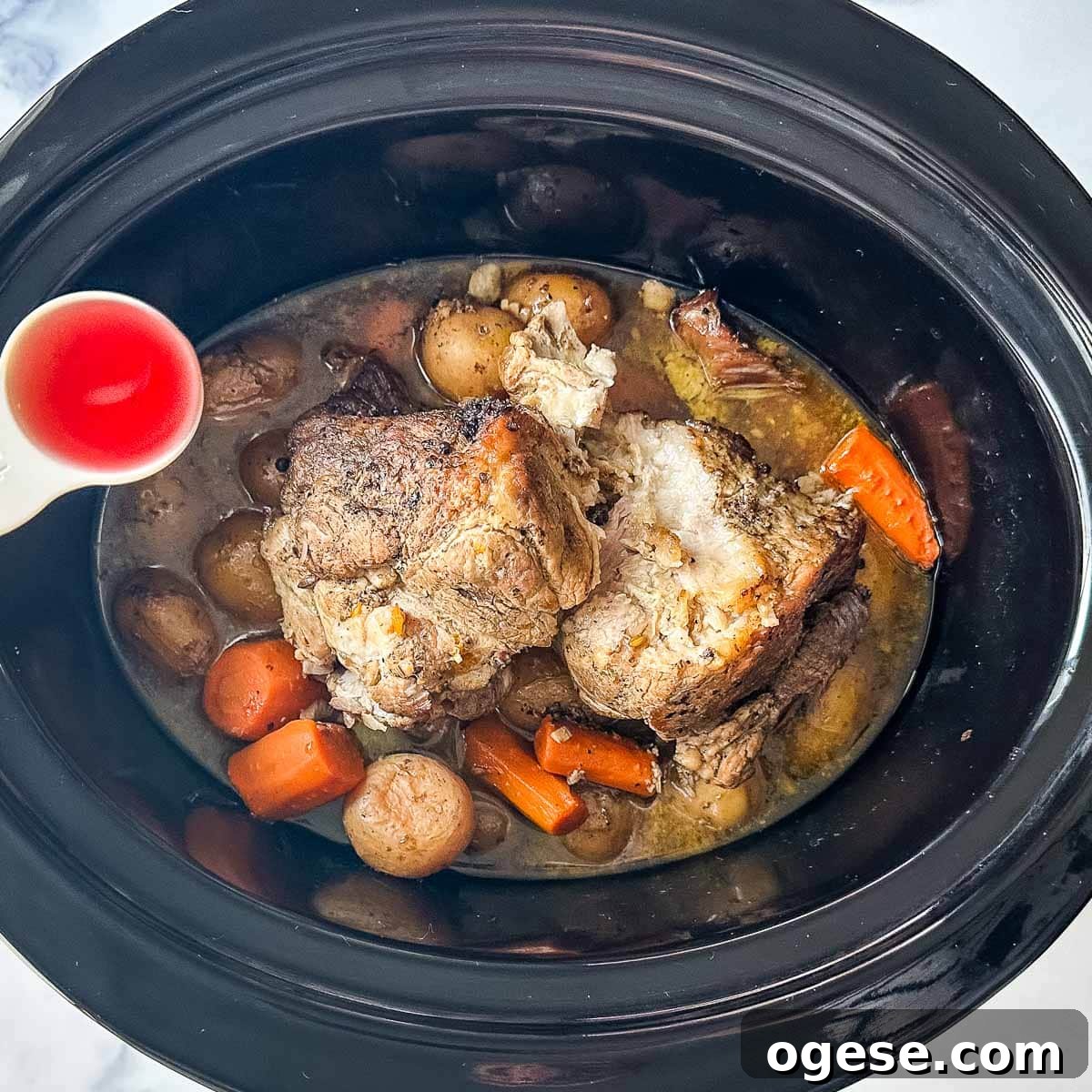 Slow Cooker Italian Pork Roast with Garlic and Herbs 18 Red wine vinegar is added to a crock pot full of pork and vegetables.