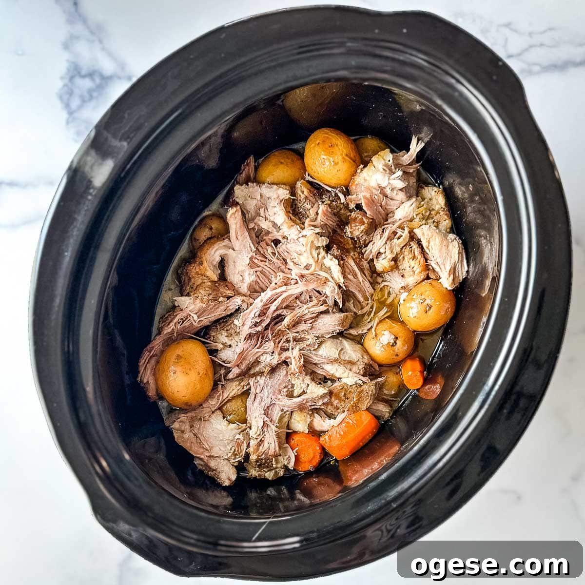 Slow Cooker Italian Pork Roast with Garlic and Herbs 20 A crock pot full of shredded pork roast, potatoes and carrots.