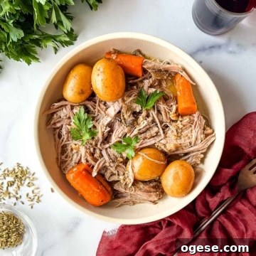 Slow Cooker Italian Pork Roast with Garlic and Herbs 23 A bowl of roast pork with carrots and potatoes.