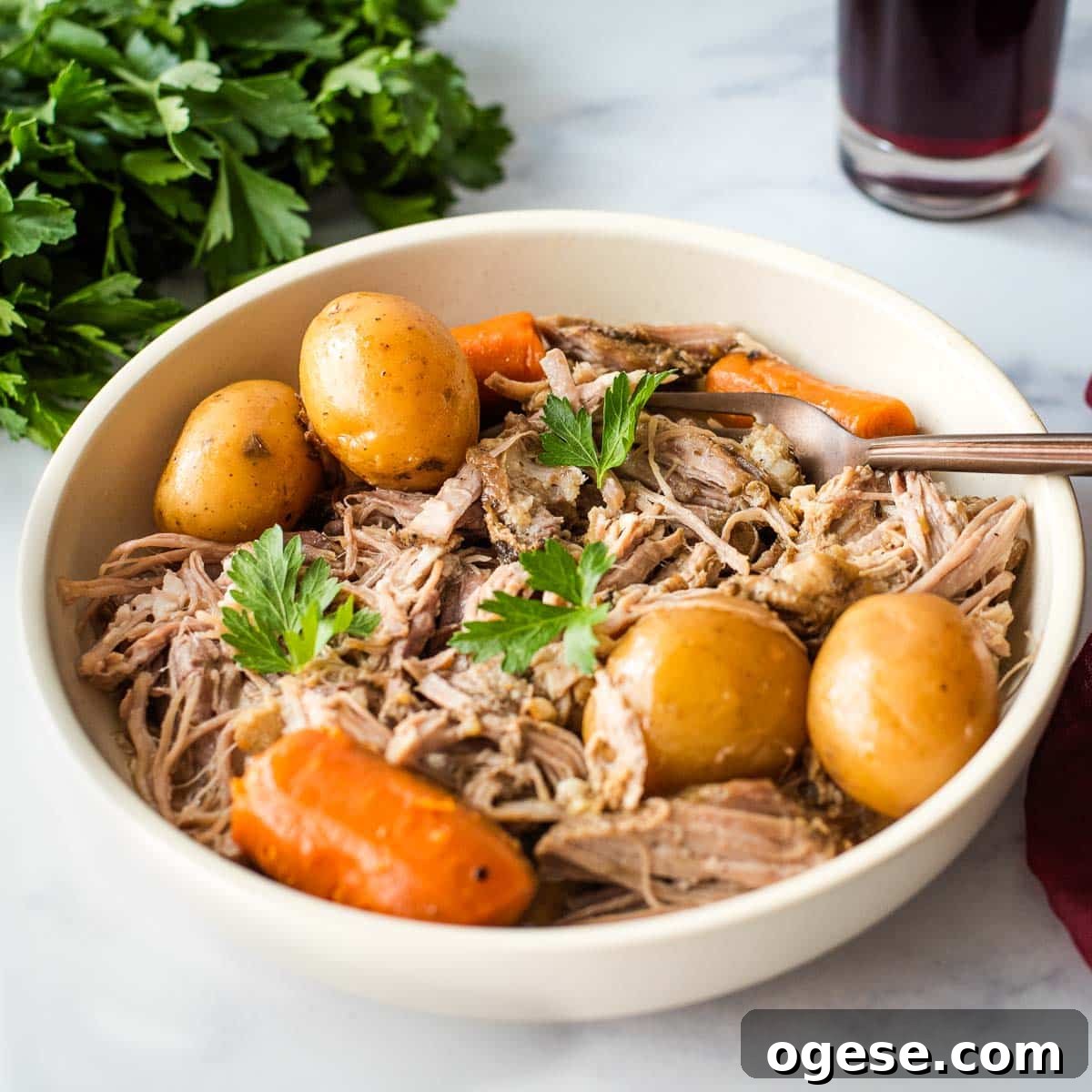Slow Cooker Italian Pork Roast with Garlic and Herbs 5 A bowl of roast pork with potatoes and carrots.